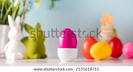 Easter card with bright colored eggs and hares on a blue background. Happy Easter. Copy space.