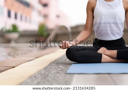 Black woman practice yoga asana on blue yoga mat beside the swimming pool at her residence to relax  body, mind and meditation in the morning for body flexibility, wellness, mental health care Royalty-Free Stock Photo #2131634285