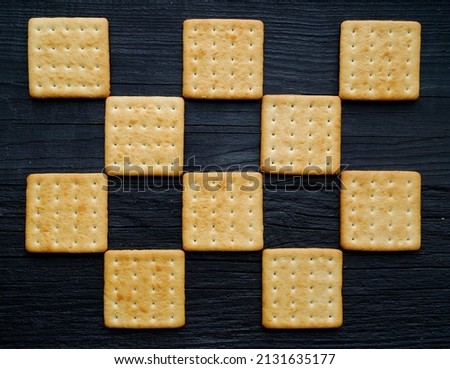 Cookies lie on a black background in a checkerboard pattern