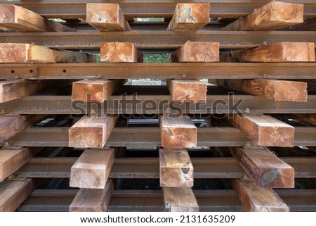 Old railway tracks stored with wooden boards.
