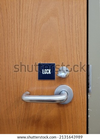 Stainless steel bathroom door handle with small "Lock" sign 
