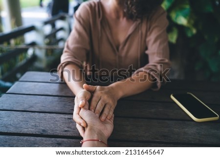 Cropped male and female hands holding each other during esoteric ritual for discussing theta holistic healing during live consultation and assistance, unrecognizable people talking about problems Royalty-Free Stock Photo #2131645647
