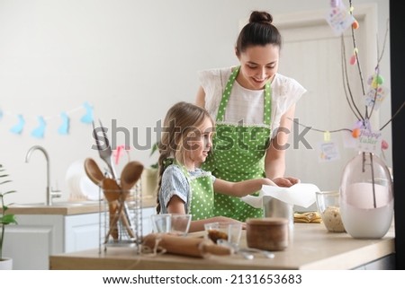 Little girl with her mother preparing Easter cake in kitchen Royalty-Free Stock Photo #2131653683