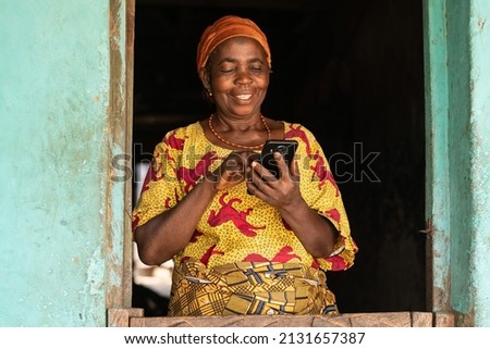 smiling elderly african woman using her phone Royalty-Free Stock Photo #2131657387