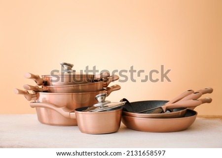 Set of copper utensils on table against color background Royalty-Free Stock Photo #2131658597