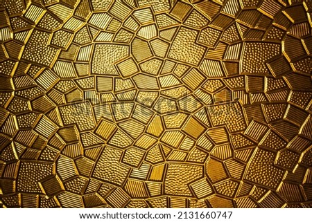 Golden antique background with polygonal texture. Gold plate with a geometric pattern, close-up.