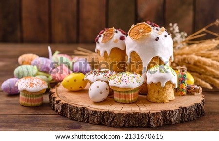 Festive cakes with white glaze, nuts and raisins on the festive table. Preparations for Easter