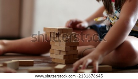 Sibling destroying sister building blocks. Little girl protecting blocks