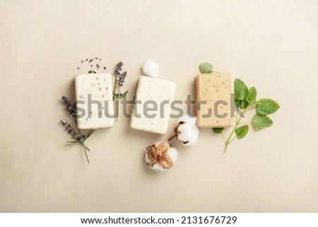 Natural soap bars and ingredients- lavender, cotton, patchouli - on natural stone background, top view. Handmade organic DIY soap, Zero waste cosmetics concept Royalty-Free Stock Photo #2131676729
