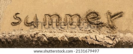 The word summer written in letters on the wet yellow sand, the inscription on the beach shoreline. Royalty-Free Stock Photo #2131679497