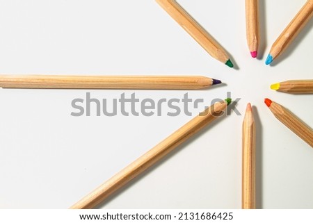 colorful pencils , different colored wooden pencils lined up in a circle and pointing at each other