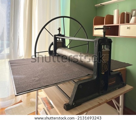 Etching press ancient engraving old machine for printmaking. Art equipment in studio. Space for text. Linocut, woodcut, etching, monotype, print, embossing, stamp art printing step process hand made

 Royalty-Free Stock Photo #2131693243