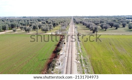 Aerial view picture of the railway track in the open countryside with the high voltage cable running along the railroad