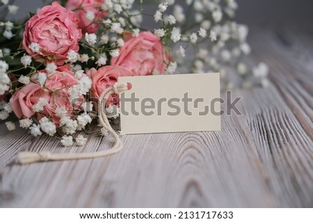 Bouquet of flowers and blank white card for text. Mockup tag. Postcard