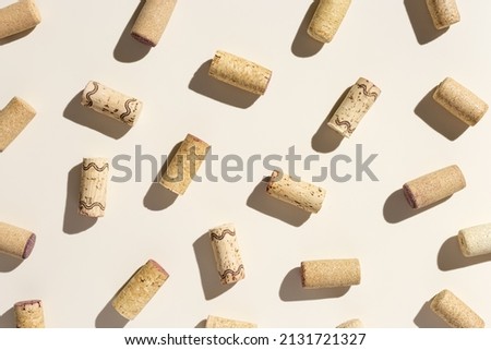 Pattern with wine corks from white and red wine on beige pastel color background with hard light and shadow at sunlight. Trend layout with bottle cap wooden cork, top view, minimal flat lay Royalty-Free Stock Photo #2131721327