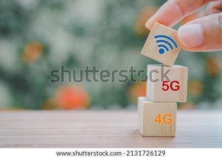 hand holding wifi icon on wood, put of top with blurred background for communication, technology, modern lifestyle concept