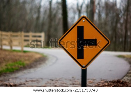 Photo of a "T" Intersection sign next to a pathway.