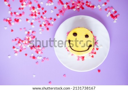 yellow cake emoji with small hearts on a purple background. Valentine's day and birthday concept