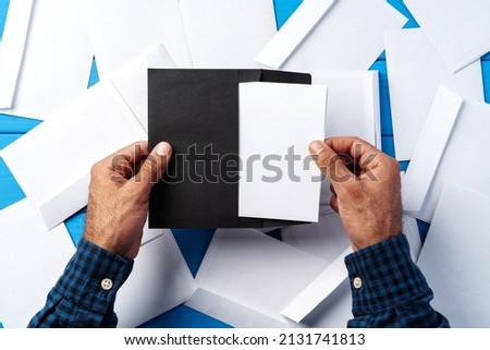 Business correspondence. Top view of man hands holding mockup envelope with letter.