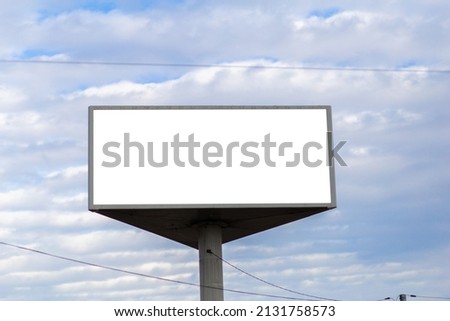White screen billboard mockup against sky with clouds.