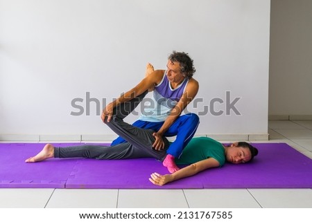 Thai Massage stretch for the quadriceps muscles (thigh and leg). Male massage therapist, female client. Royalty-Free Stock Photo #2131767585