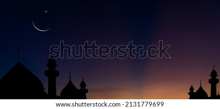 Silhouette dome mosques and crescent moon on dusk sky twilight in the evening religion of Islamic on Ramadan Kareem, Eid Al Fitr, Eid Al Adha and free space for text arabic  Royalty-Free Stock Photo #2131779699
