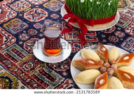 Plate of Azerbaijani national pastries for Novruz pakhlava and shakarbura on ethnic rug or carpet for Novruz, spring equinox and new year celebration in March. Copy space  