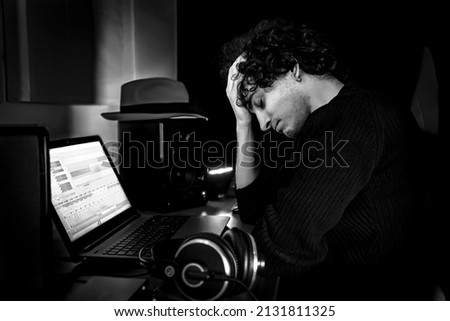 Frustrated Guy in studio during music production session. Image in black and white.