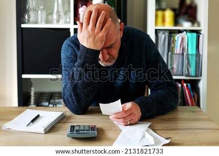 Man upset headache depressed from family cost got higher doing accounting holding receipts from supermarket with calculator by rising grocery prices and surging cost as an inflation financial crisis. Royalty-Free Stock Photo #2131821733