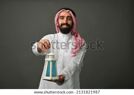 Saudi arab man holding ramadan lantern traditional dress Royalty-Free Stock Photo #2131821987