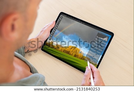 Man editing photo on tablet computer