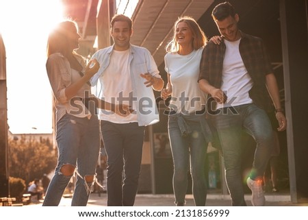 Young friends hang out on the city street.They go for walks together and have fun in the city downtown. Royalty-Free Stock Photo #2131856999