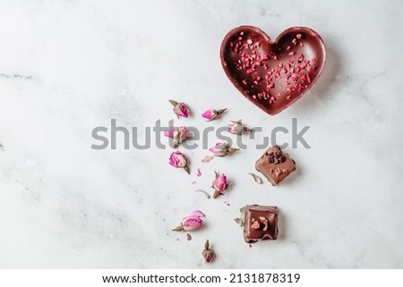 Chocolate candies with berries and nuts on a light background. Handmade chocolate with colors and space for text. Mocap of sweets and desserts
