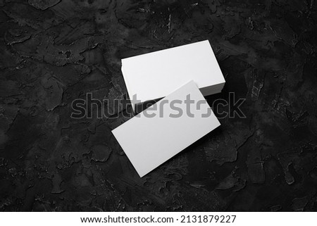 Photo of blank business cards on black stone background. Template for ID.