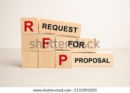three wooden cubes with the letters RFP on the bright surface of a gray table. the inscription on the cubes is reflected from the surface of the table. Royalty-Free Stock Photo #2131892005
