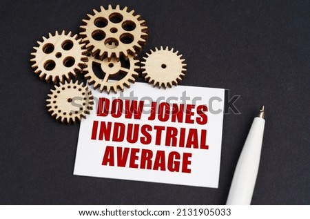 Industrial concept. On the black surface are gears, a pen and a business card with the inscription - Dow Jones Industrial Average Royalty-Free Stock Photo #2131905033