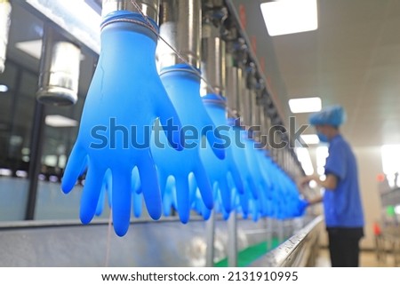 workers spot check the product quality of nitrile gloves on the production line, China Royalty-Free Stock Photo #2131910995