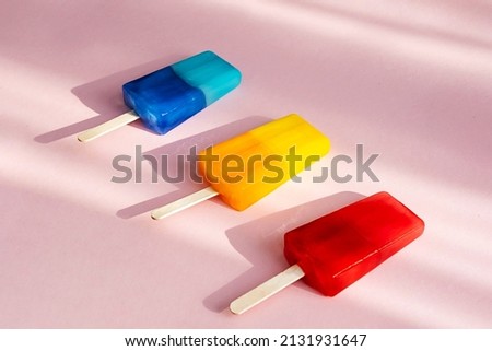 Colored popsicles against pink background. Various bright ice cream. Summer concept.
