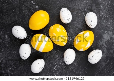 Yellow easter eggs on black background, happy easter concept. Festive background, flat lay.
