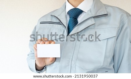 A businessman with a business card. Men in work clothes.