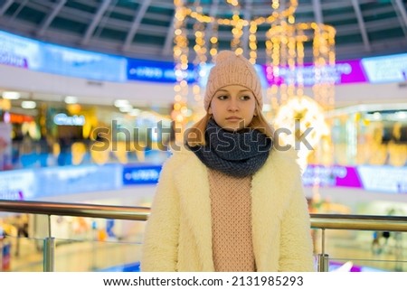 teenage girl in white jacket in shopping mall