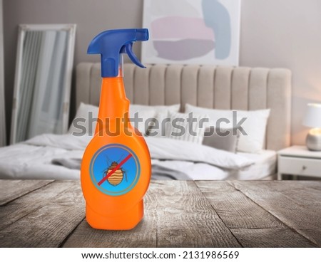 Anti bed bug spray on wooden table in bedroom. Space for text