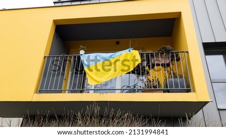 Ukraine national flag of the state flutters yellow blue in the wind on the balcony of an residential building