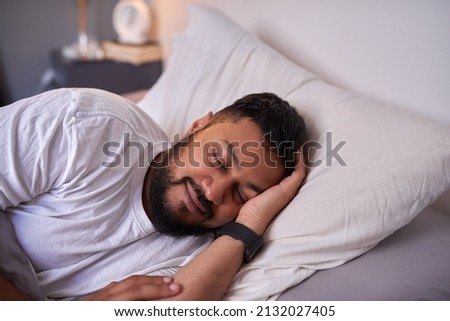 An adult man sleeps peacefully with a smile in bed in the morning. High quality photo