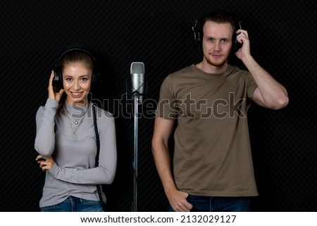 Portrait of young and beautiful and handsome male singers working together in voice recording studio with fun and happiness, they pose to camera with relax for album cover photo.