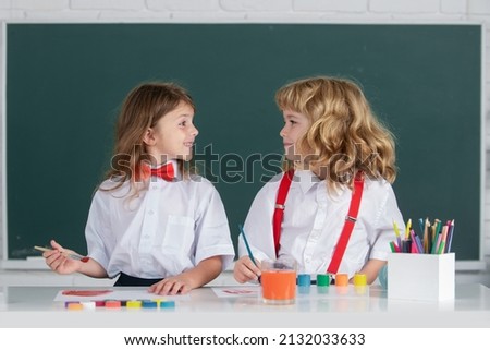 School children drawing a colorful pictures with pencil crayons in classroom. Portrait of cute pupils enjoying art and craft lesson. Best children friends enjoying friendship.