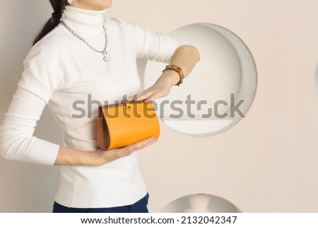 yellow lacquered leather purse close up photo in human hand