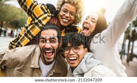 Group of four best friends laughing out loud outside - Multicultural young people enjoying day out together - Youth culture concept with guys and girls having fun on city street  Royalty-Free Stock Photo #2132047209