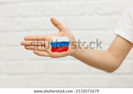 Flags of Russia  painted on a hands. Relationship between Ukraine and Russia