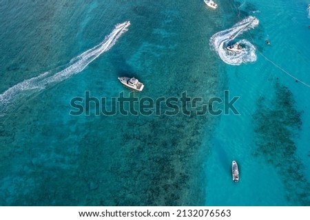 Drone aerial view of jet ski and boat sailing next to Cove beach, Paradise Island, Nassau.